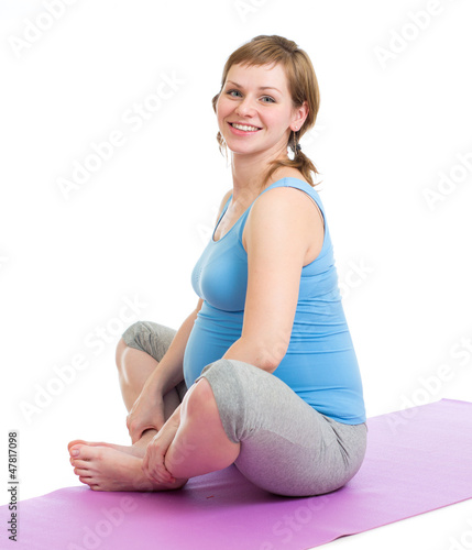Photo: Pregnant woman doing gymnastic exercises isolated on white Pregnant woman doing gymnastic exercises isolated on white
