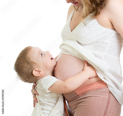 Photo: Little boy hugging pregnant mother's belly and looking up Little boy hugging pregnant mother's belly and looking up