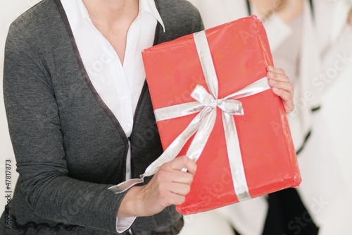 Photo: Frau packt Geschenk aus Frau packt Geschenk aus