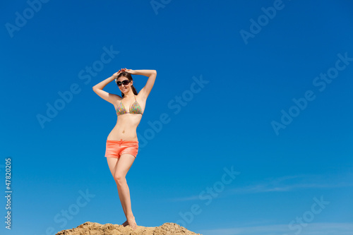 Photo: Portrait of young woman in bikini at beach Portrait of young woman in bikini at beach