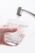 Wasserglas wird am Wasserhahn gefüllt