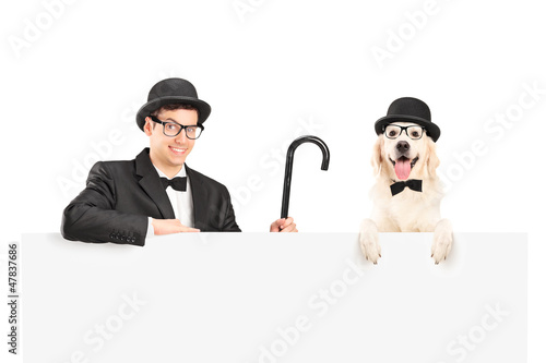 Photo: A performer in suit, retro hat and cane posing with dog behind a A performer in suit, retro hat and cane posing with dog behind a