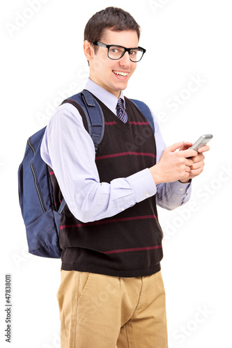 Photo: Smiling student with backpack typing a sms on a phone Smiling student with backpack typing a sms on a phone