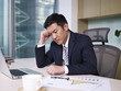 frustrated asian businessman thinking in office