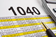 Tax forms 1040, spread sheet with pen and calculator.