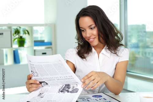 Photo: Businesswoman reading news Businesswoman reading news