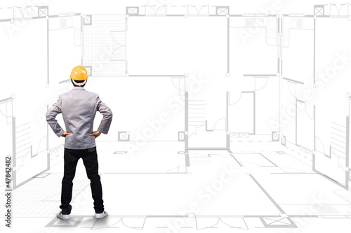 Photo: Engineering person standing near a House blueprints Engineering person standing near a House blueprints