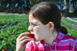 girl eating the strawberry on farm