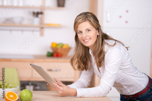 Photo: frau mit touchpad in der küche frau mit touchpad in der küche
