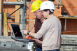 Civil engineer and construction worker looking at the laptop