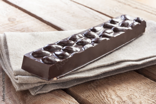 Photo: Delicious chocolate bar with almonds on canvas Delicious chocolate bar with almonds on canvas