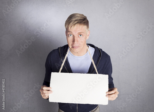 Photo: Unhappy man holding empty signboard with space for text. Unhappy man holding empty signboard with space for text.