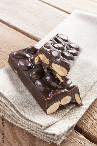 Photo: Delicious chocolate bar with almonds on canvas Delicious chocolate bar with almonds on canvas