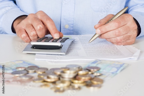 Photo: Business men working with documents and calculator Business men working with documents and calculator