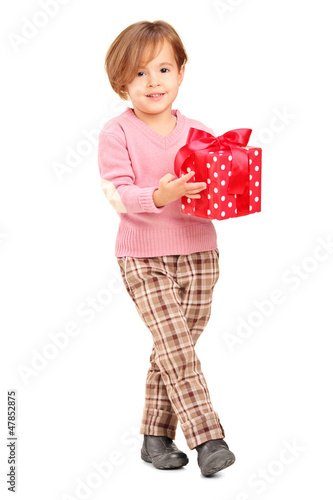 Photo: Full length portrait of a smiling child holding a gift Full length portrait of a smiling child holding a gift