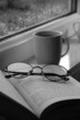 A book , glasses and window with raindrops