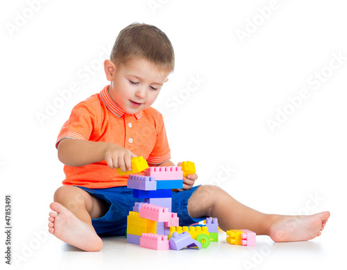 Photo: cheerful child boy playing with construction set over white back cheerful child boy playing with construction set over white back
