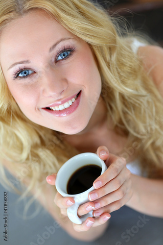Photo: Upper view of blond woman drinking coffee Upper view of blond woman drinking coffee