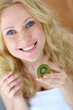 Portrait of beautiful girl eating kiwi