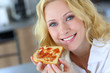 Beautiful girl eating toasted bread for breakfast