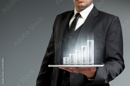 Photo: Financial report & statistics. Bar graph on tablet pc. Financial report & statistics. Bar graph on tablet pc.
