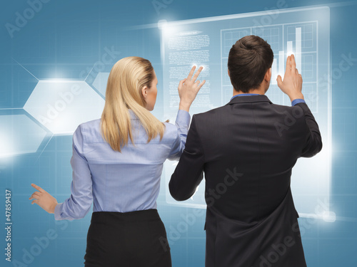 Photo: man and woman working with virtual screens man and woman working with virtual screens