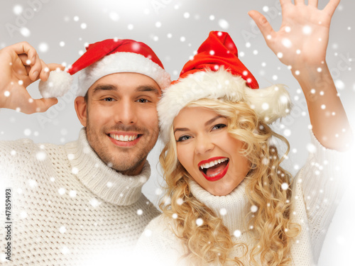 Photo: family couple in sweaters and santa's hats family couple in sweaters and santa's hats