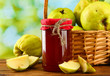 jar of jam and quinces with leaves in basket,
