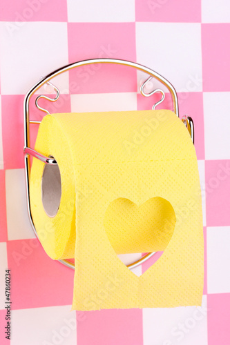 Photo: Roll of toilet paper on holder fixed to wall in bathroom Roll of toilet paper on holder fixed to wall in bathroom