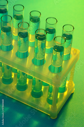 Photo: test-tubes with liquid on blue background test-tubes with liquid on blue background