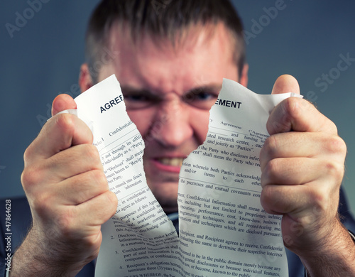 Photo: Businessman tearing agreement Businessman tearing agreement