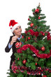 woman  putting christmas ball on  christmas tree