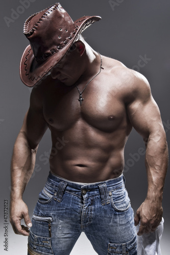 Photo: A muscular man in a cowboy hat A muscular man in a cowboy hat