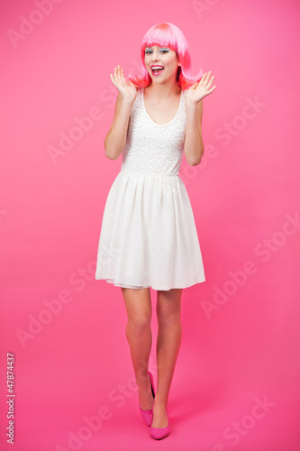 Photo: Beautiful young woman over pink background Beautiful young woman over pink background