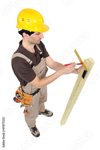 Photo: Carpenter using a angle iron. Carpenter using a angle iron.
