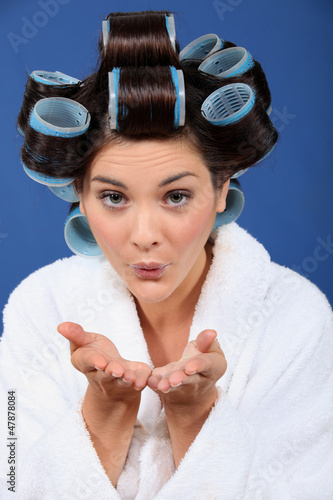 Photo: Woman with her hair in rollers blowing a kiss Woman with her hair in rollers blowing a kiss