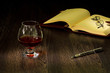Cognac, cigar and an old book nearby
