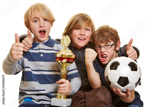 Photo: Jungs mit Pokal und Fußball halten Daumen hoch Jungs mit Pokal und Fußball halten Daumen hoch