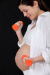 Pregnant woman lifting dumbbells
