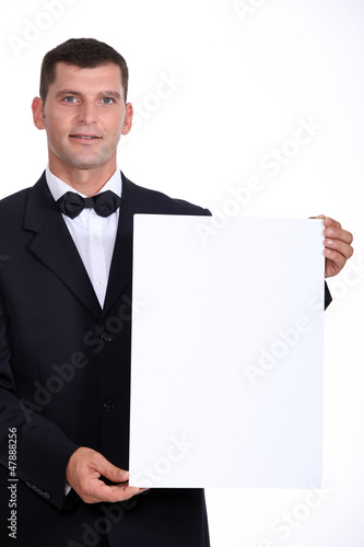 Photo: Man wearing bow-tie holding white board Man wearing bow-tie holding white board