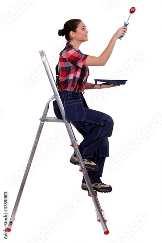 Photo: Woman painting a pretend wall with a roller Woman painting a pretend wall with a roller