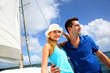 Smiling rich young couple on a sailboat in Caribbean sea