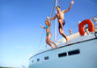 Young couple jumping in water from yacht