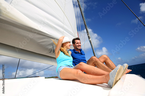 Photo: Cheerful couple cruising on a catamaran in Caribbean sea Cheerful couple cruising on a catamaran in Caribbean sea