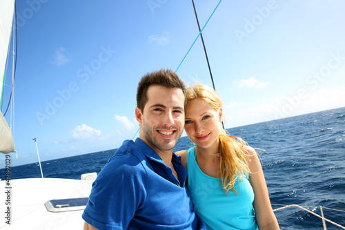 Photo: Portrait of couple sitting on the top of sailing boat Portrait of couple sitting on the top of sailing boat
