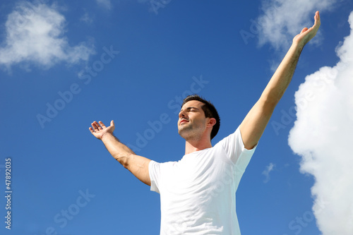 Photo: Man stretching arms up towards the sky Man stretching arms up towards the sky