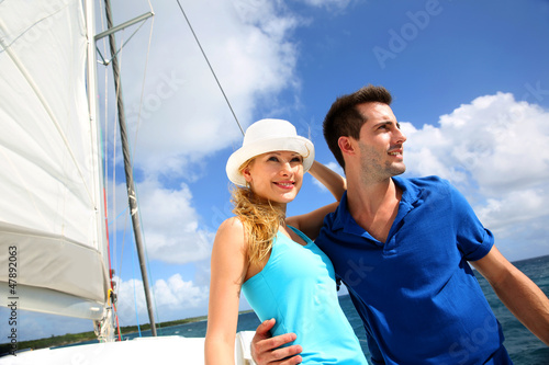 Photo: Smiling rich young couple on a sailboat in Caribbean sea Smiling rich young couple on a sailboat in Caribbean sea