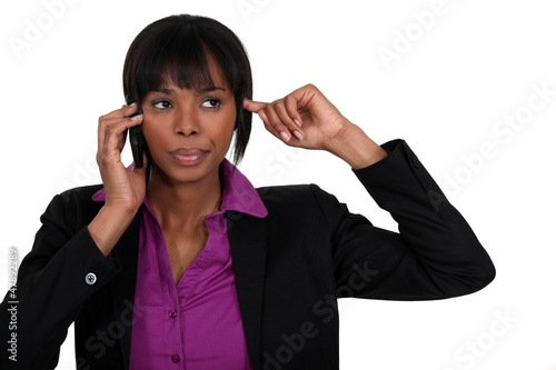 Photo: Woman putting finger in ear during call Woman putting finger in ear during call