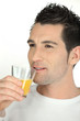 Man drinking a glass of orange juice
