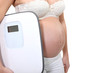 pregnant woman holding a scale